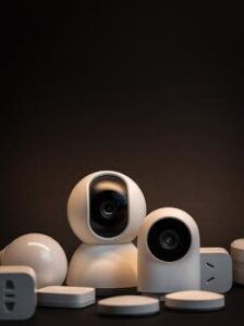 Close-up of modern white security cameras and smart home devices with dark background.